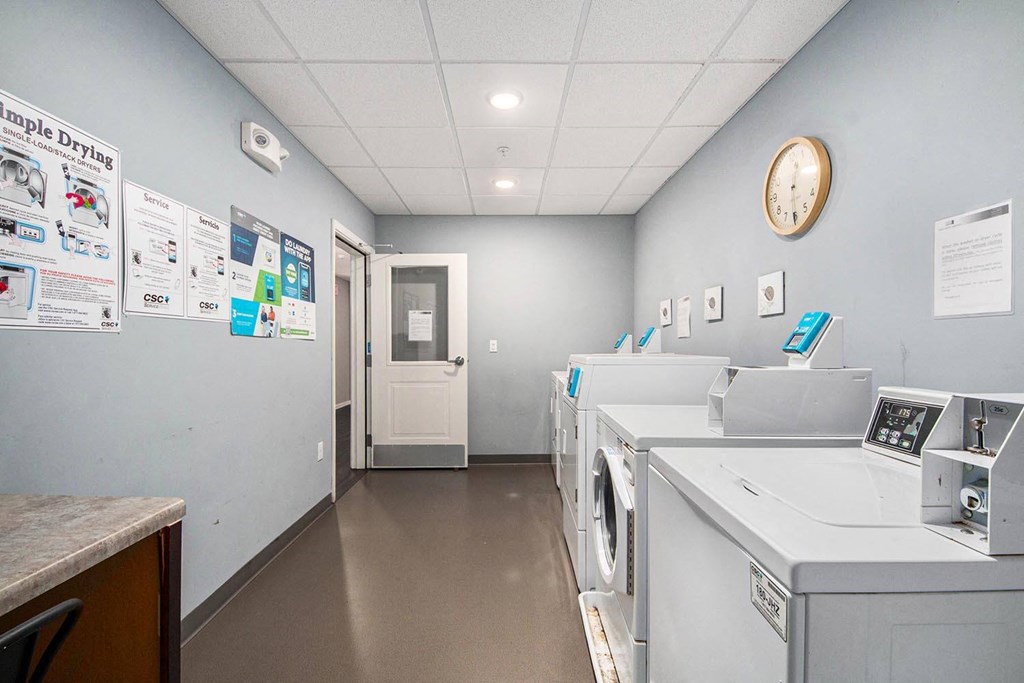 a laundry room with washing machines and a clock on the wall