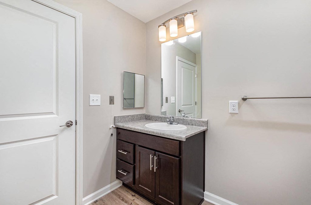 A bathroom with a sink, mirror, and lighting.