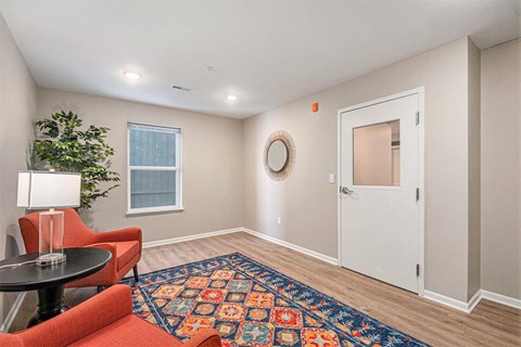 A room with a red chair and a black table.
