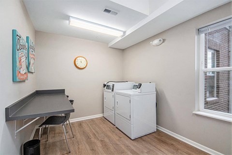 A room with a table, chairs, and a cabinet.