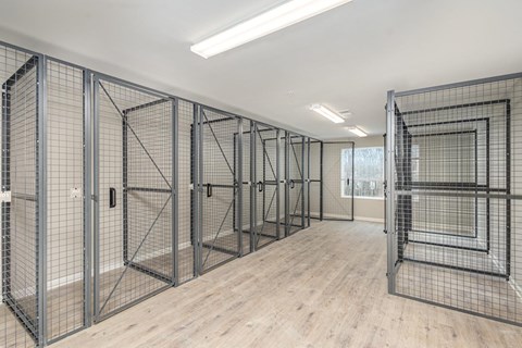 A room with a wooden floor and metal grid walls.