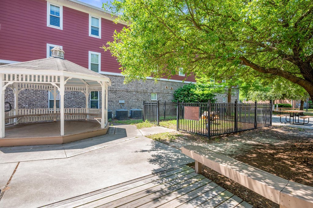 a gazebo and picnic table in front of a building