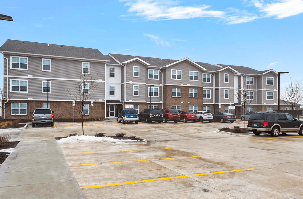 an empty parking lot in front of an apartment building