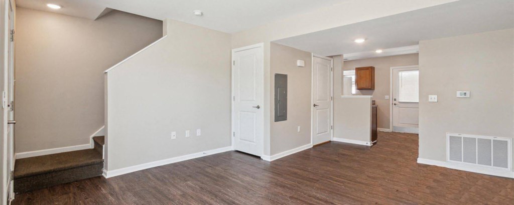 the living room and kitchen of a new home with a hard wood floor