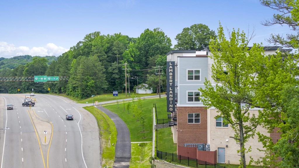A highway with cars driving on it and a building with the word Ladbrokes on it.