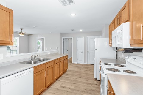 A kitchen with white appliances and wooden cabinets.