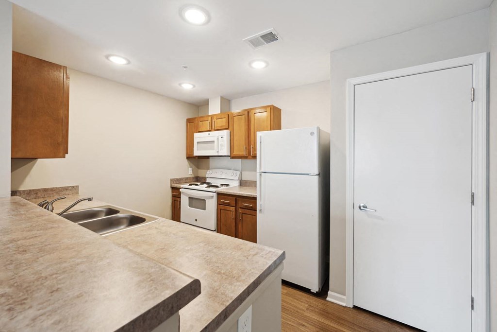 a kitchen with a white refrigerator freezer next to a stove top oven