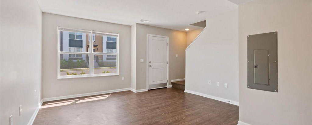 A room with a door and a window with a view of a building.