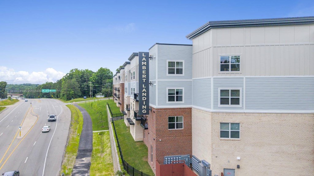 A highway with cars driving on it and a building with the words "AMERICAN FENIX" on it.