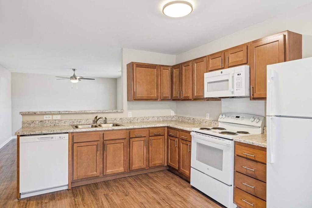 a kitchen with white appliances and wooden cabinets
