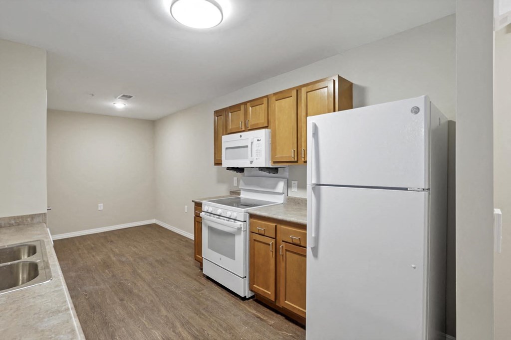 a kitchen with white appliances and wooden cabinets