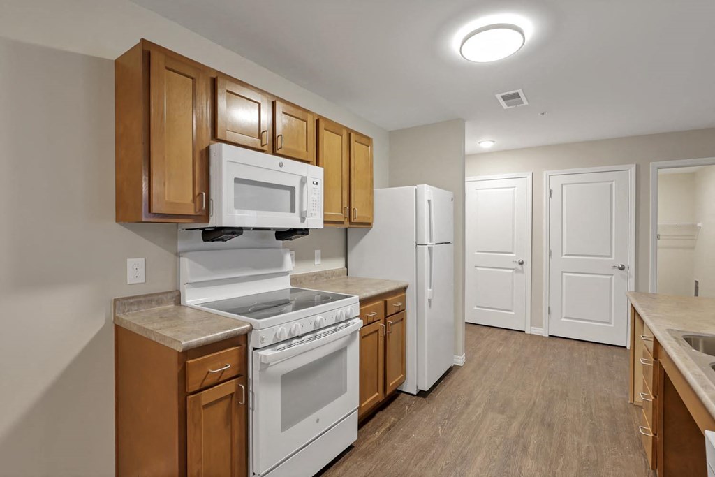 a kitchen with white appliances and wooden cabinets