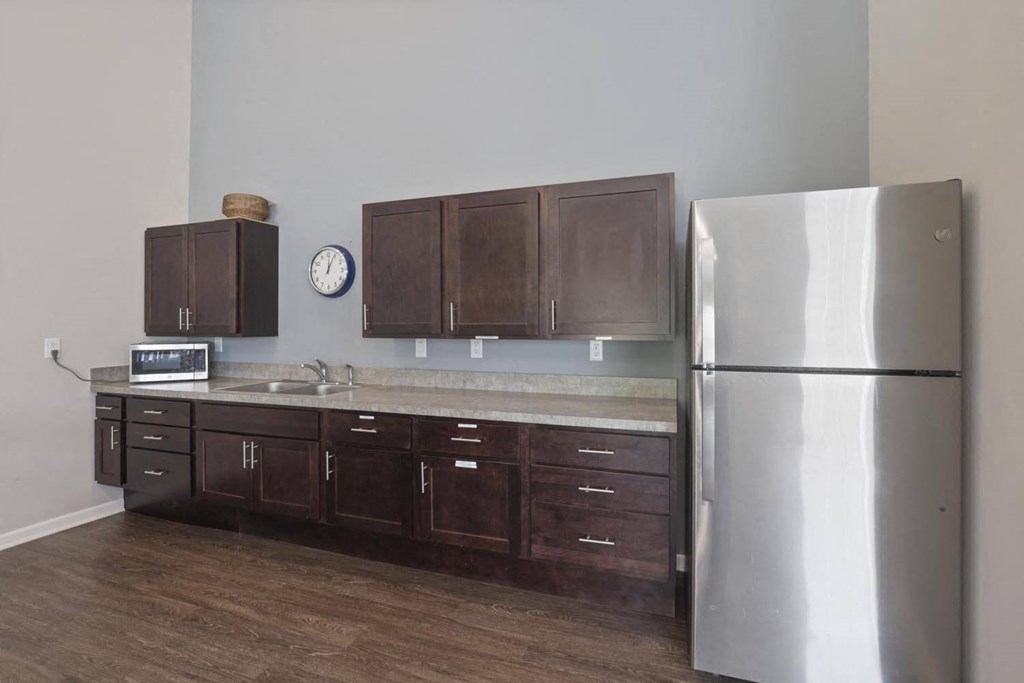 a kitchen with a stainless steel refrigerator and wooden cabinets