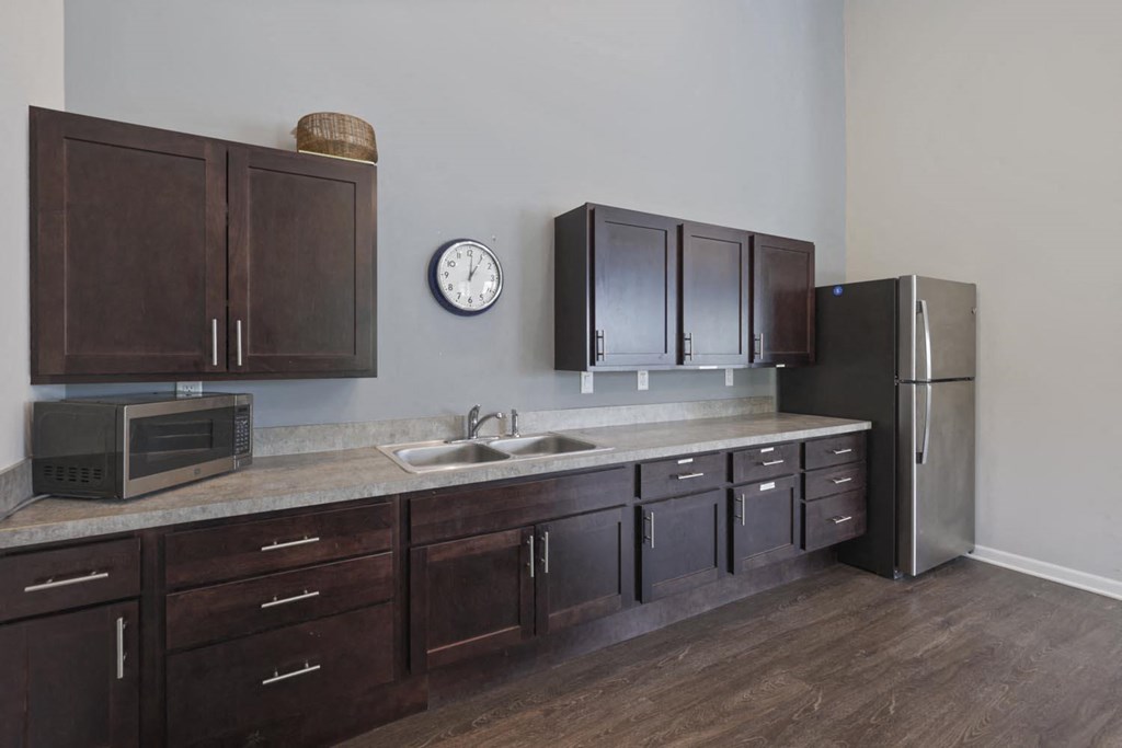 a kitchen with wooden cabinets and a clock on the wall
