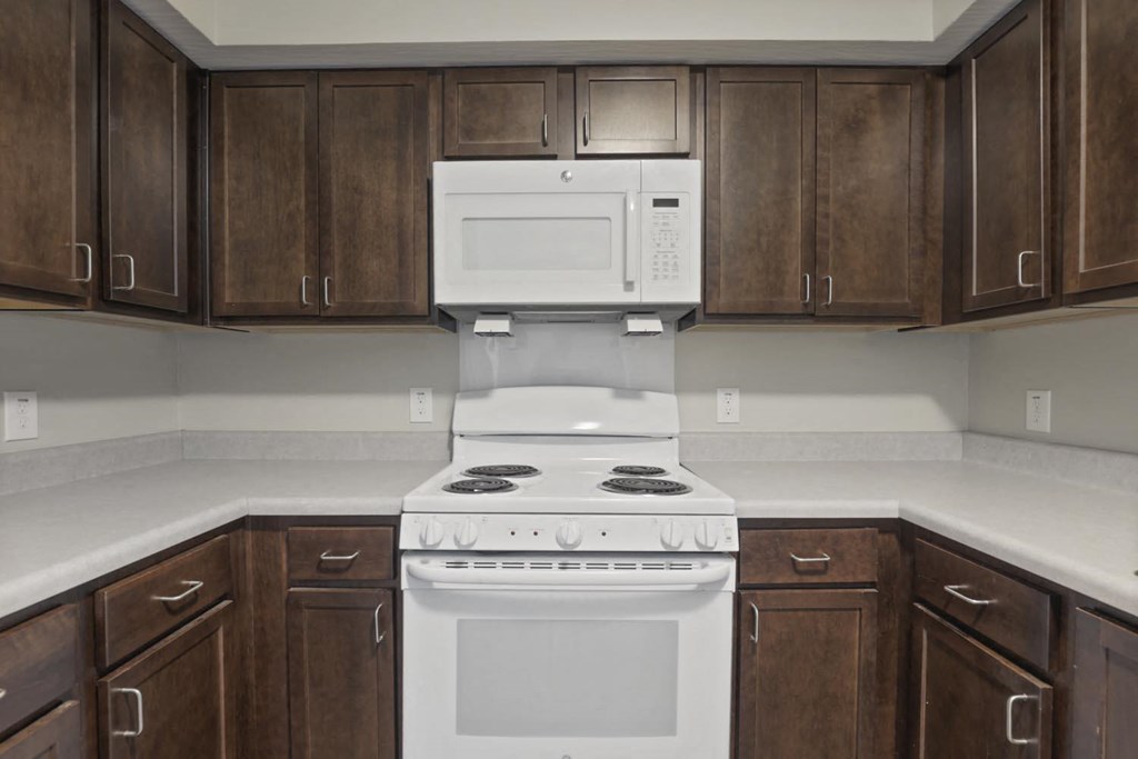 a kitchen with white appliances and wooden cabinets