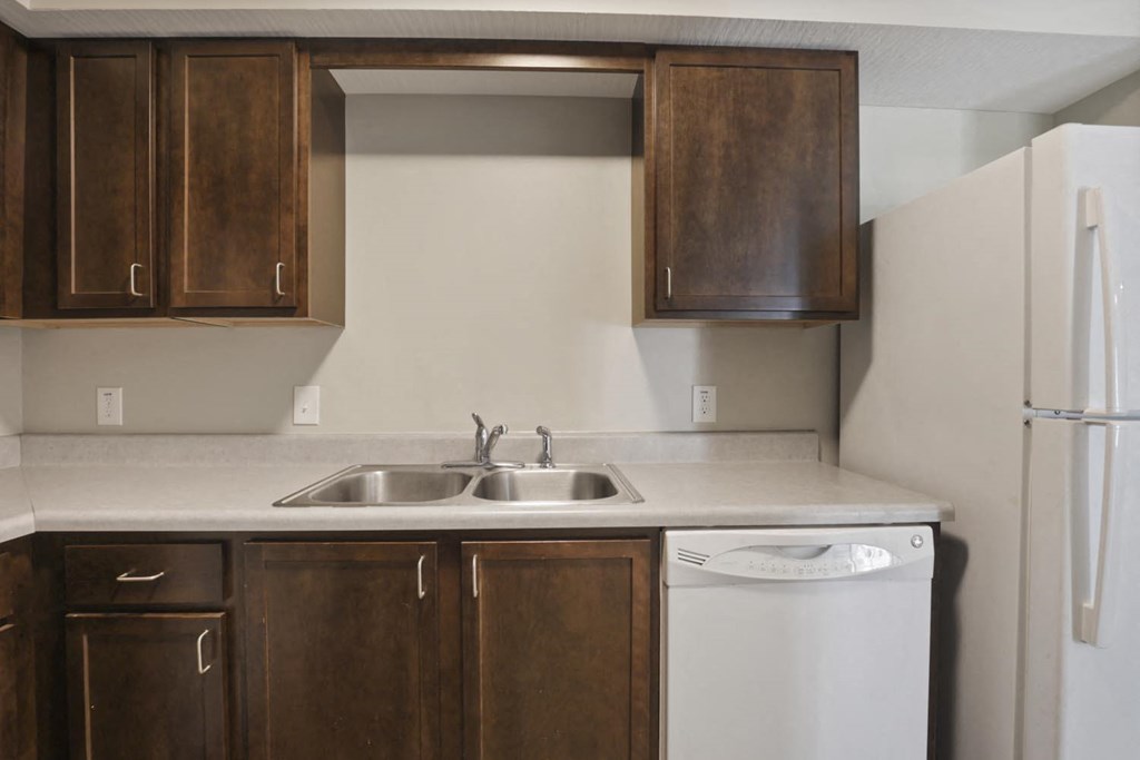 a kitchen with wooden cabinets and a white dishwasher