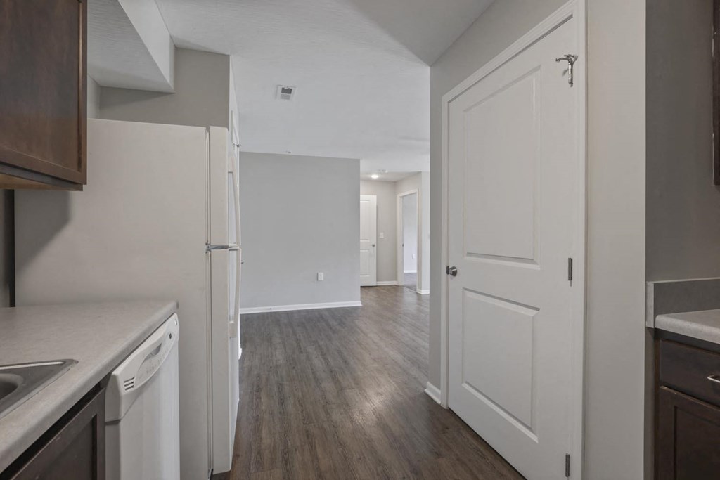 a kitchen and living room with a door open to a hallway