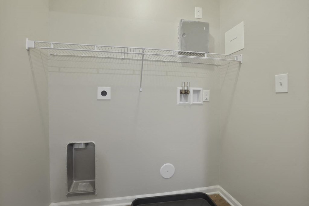 a white room with a white wall and a shelf with a toilet and a basket