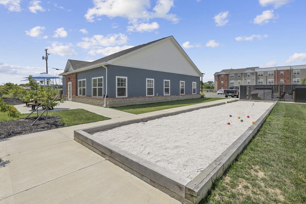 a sand volleyball court in front of a blue building
