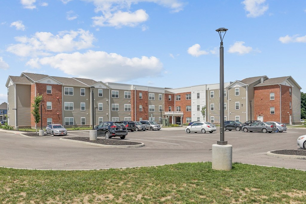 a parking lot with cars in front of an apartment building