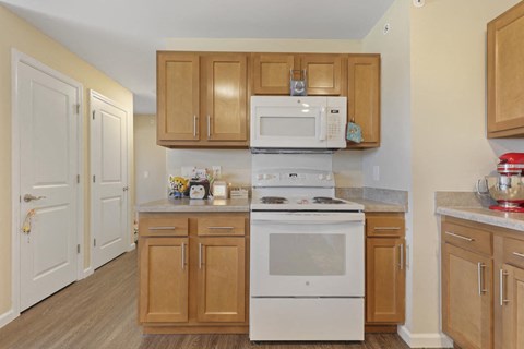 a kitchen with white appliances and wooden cabinets