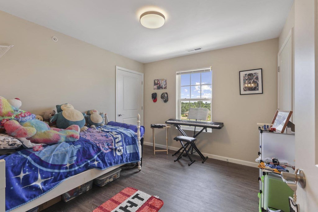 a bedroom with a bed and a desk and a window