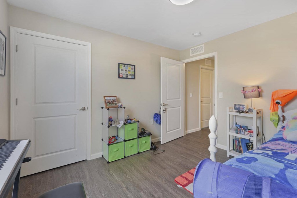 a bedroom with a bed and a piano    and a closet