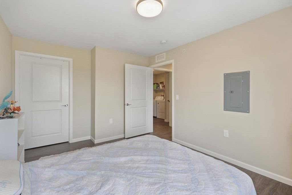 a bedroom with a large bed and a door to a bathroom