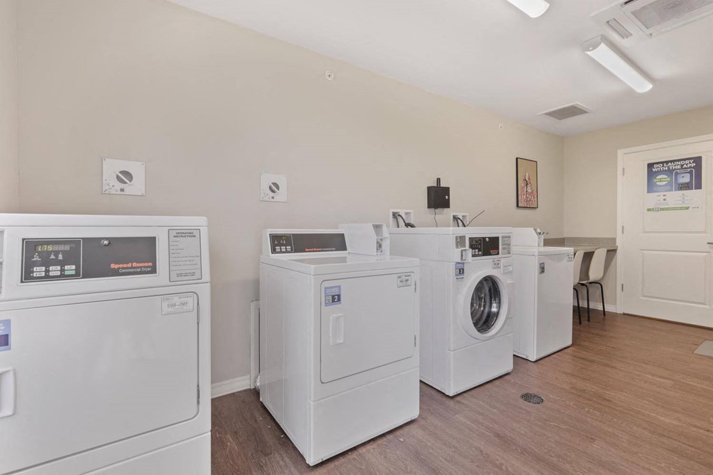 a laundry room with four washes and dryers in it
