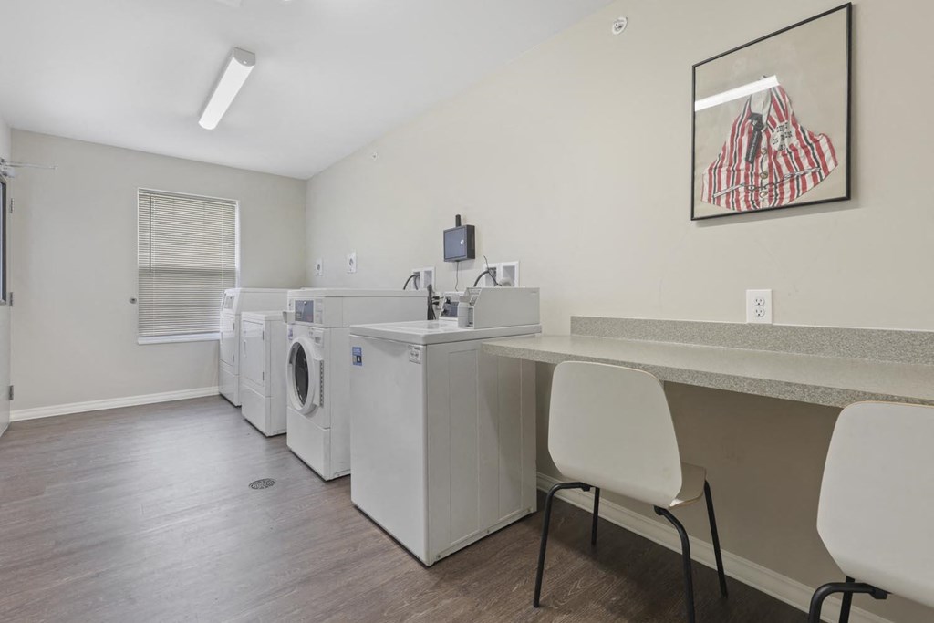 a laundry room with washers and dryers and a table with chairs