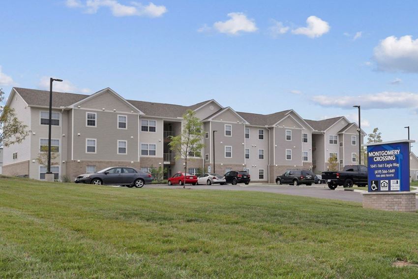 a large apartment building with cars parked in front of it
