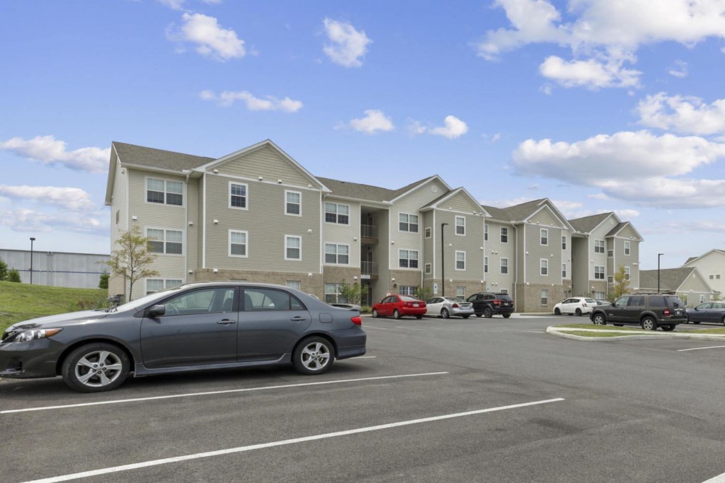 a car parked in a parking lot in front of an apartment building