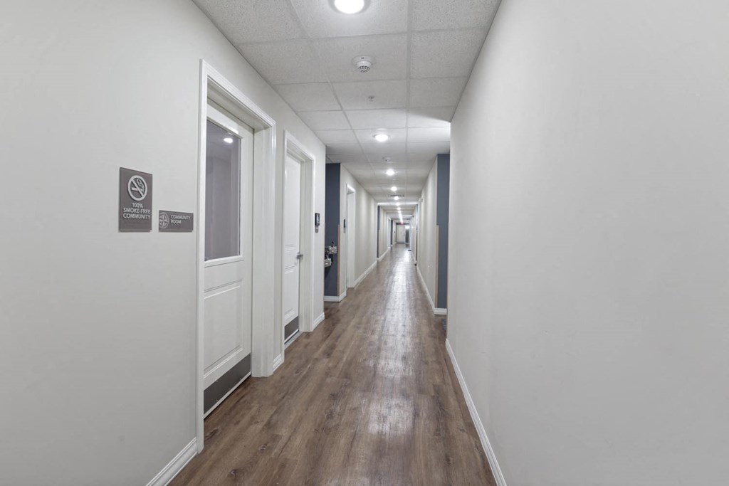 a long hallway with white walls and wooden floors