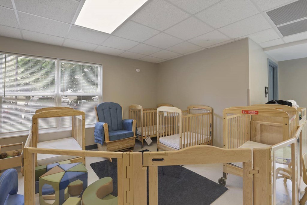 a room with cribs and chairs in a hospital room