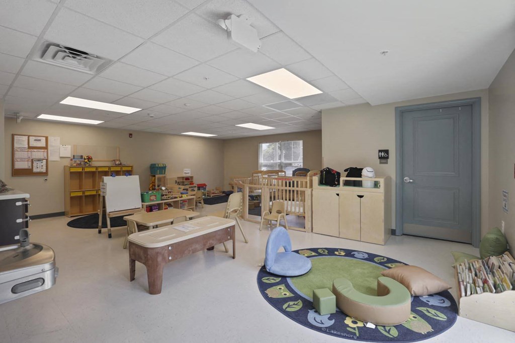 a play room with a table and chairs and a rug