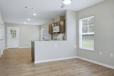 A kitchen with a white counter and wooden floors.