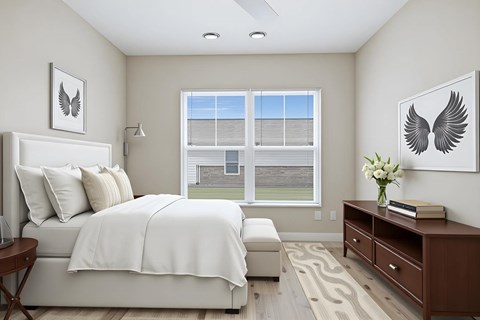 A bedroom with a large bed and a window overlooking a lawn.