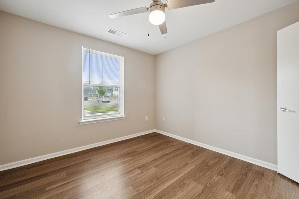 a bedroom with hardwood floors and a ceiling fan