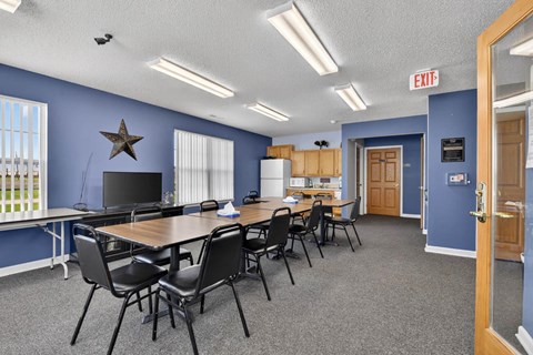 A conference room with a long table and chairs, a television, and a star decoration on the wall.