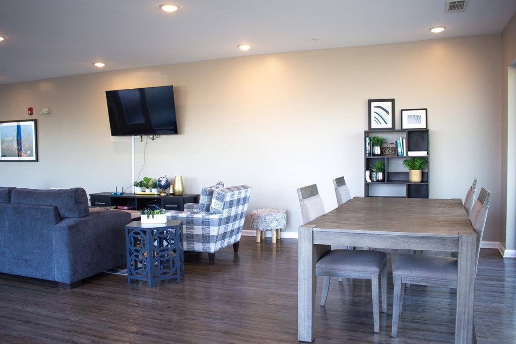 A living room with a grey couch, a wooden table, and a television.