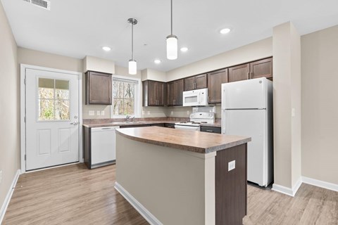 A kitchen with a white refrigerator and brown countertops.