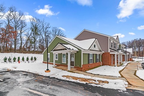 A house with a green front yard and a brown roof.