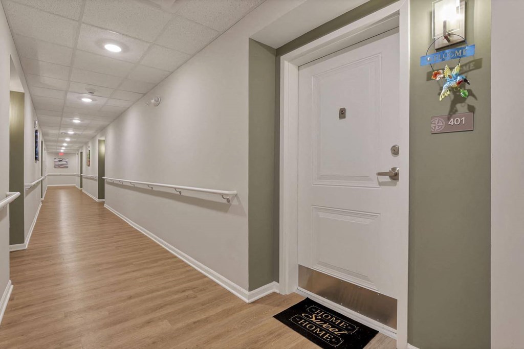 a long hallway with white walls and wood floors