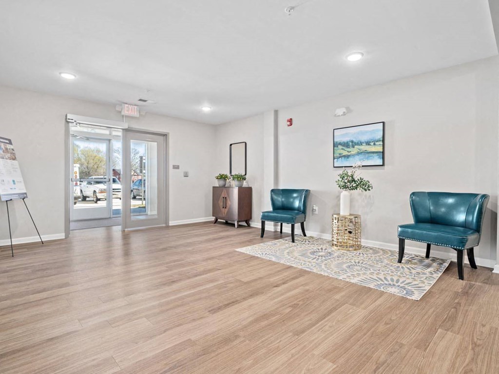 a living room with two blue chairs in front of a door