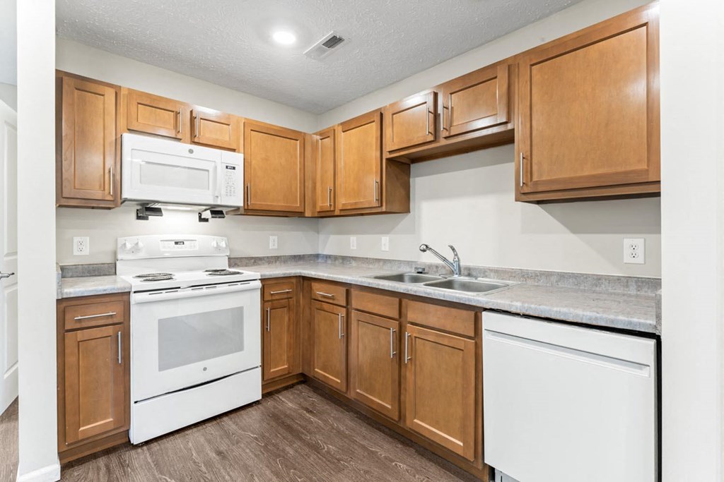 a kitchen with white appliances and wooden cabinets