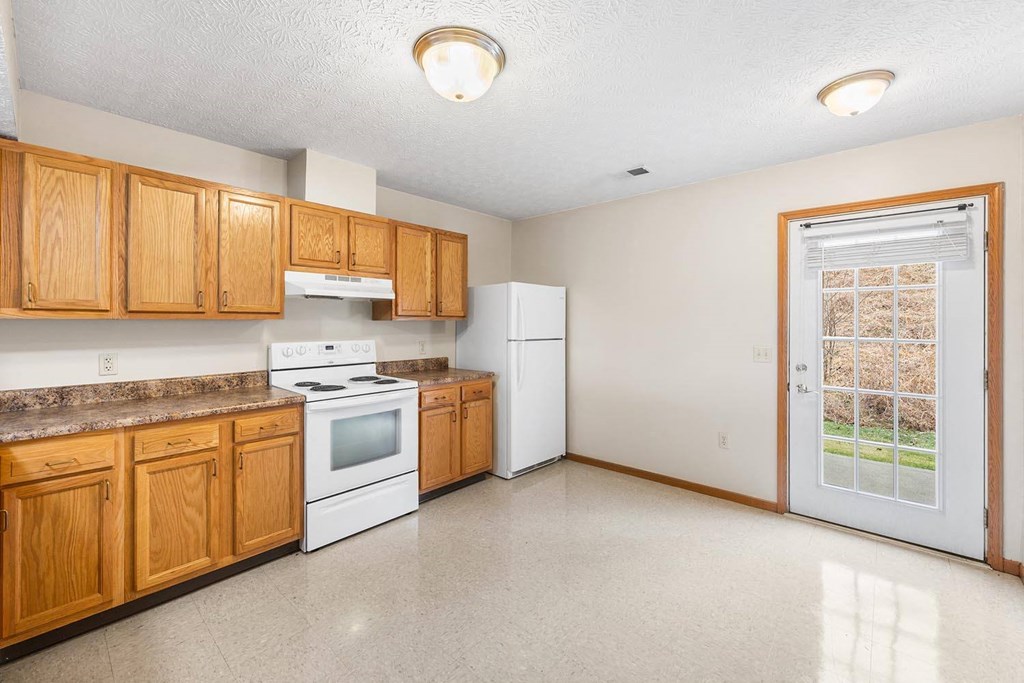 a kitchen with white appliances and wooden cabinets