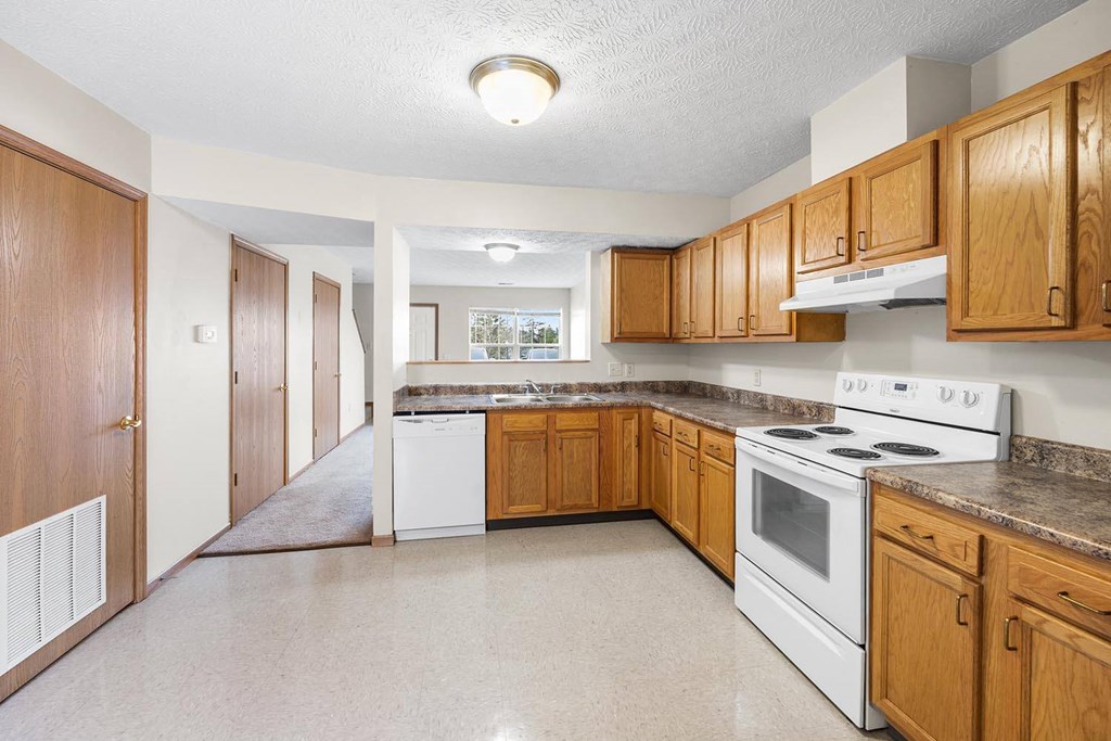 a kitchen with white appliances and wooden cabinets
