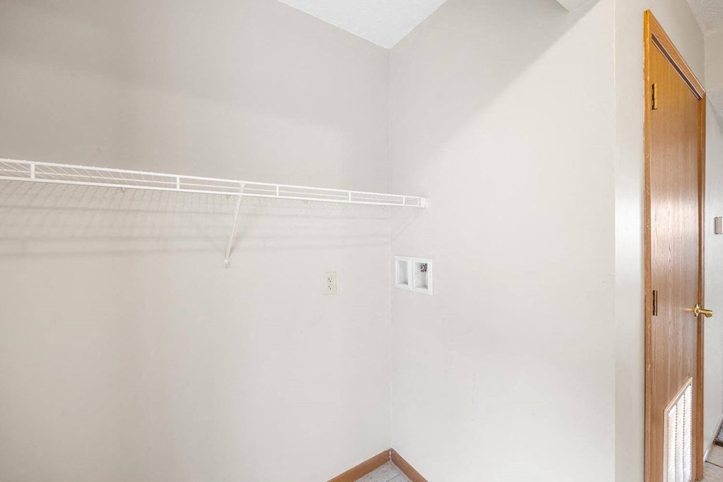 an empty closet in a white room with a white door