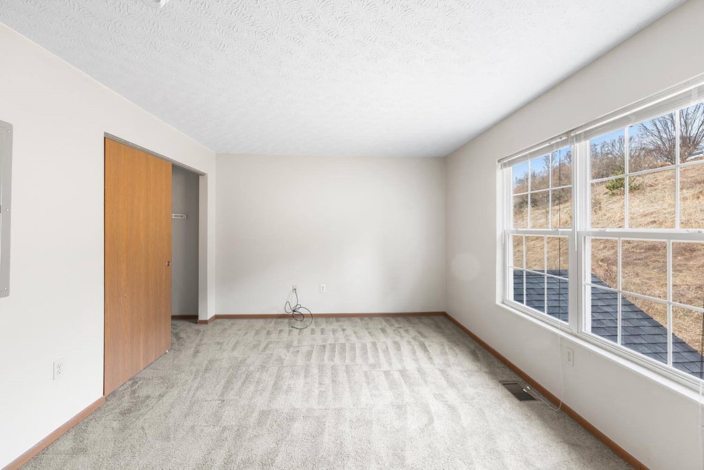 an empty room with a large window and a door