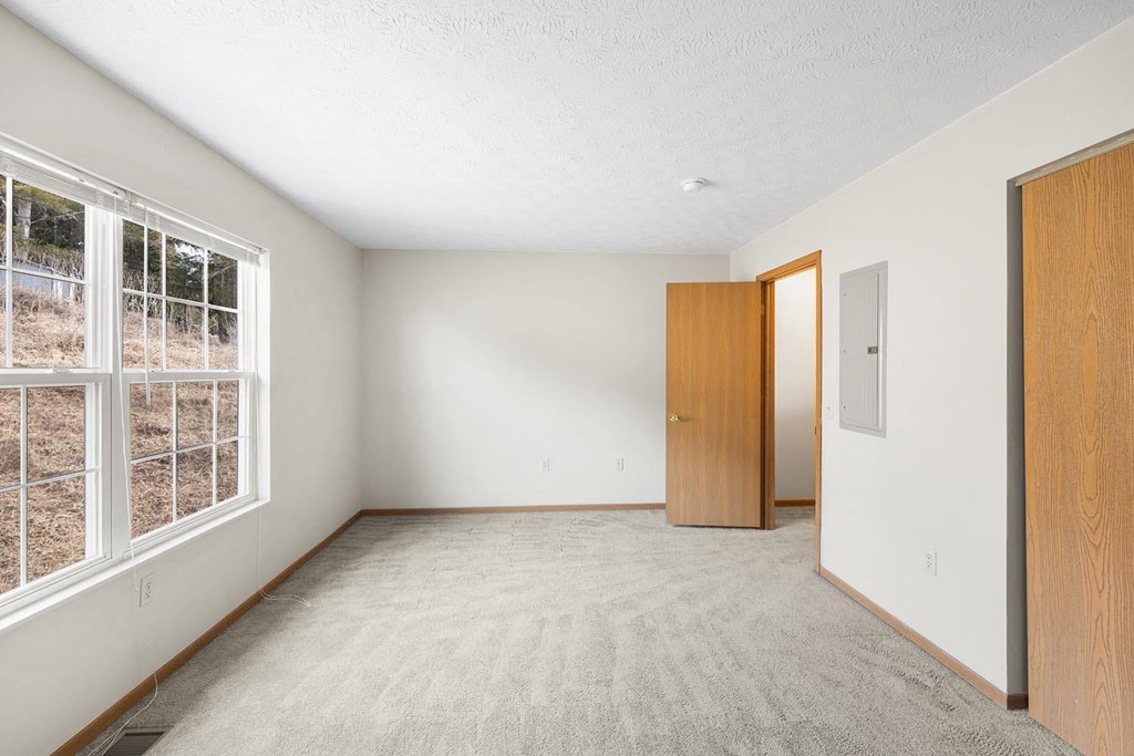 an empty room with a large window and a door